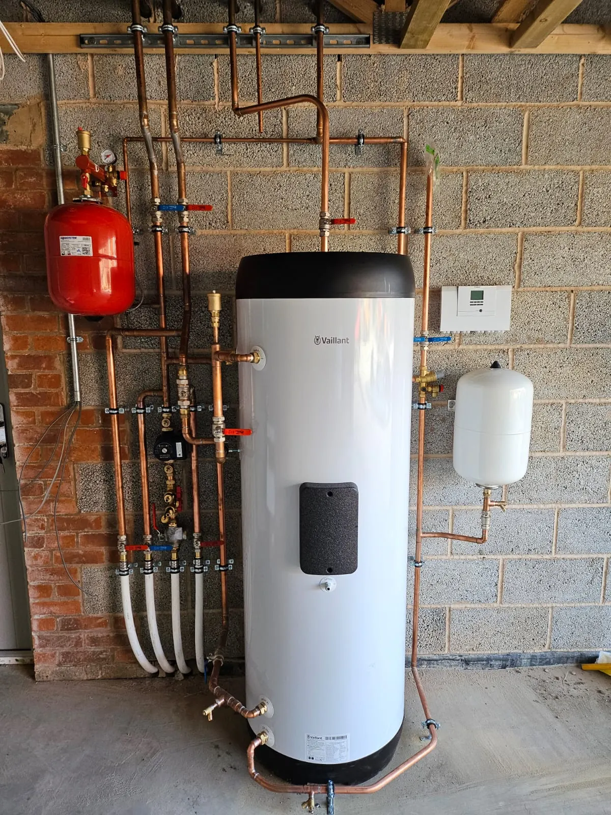 Renewable heating plant room with cylinders, valves and pipework.
