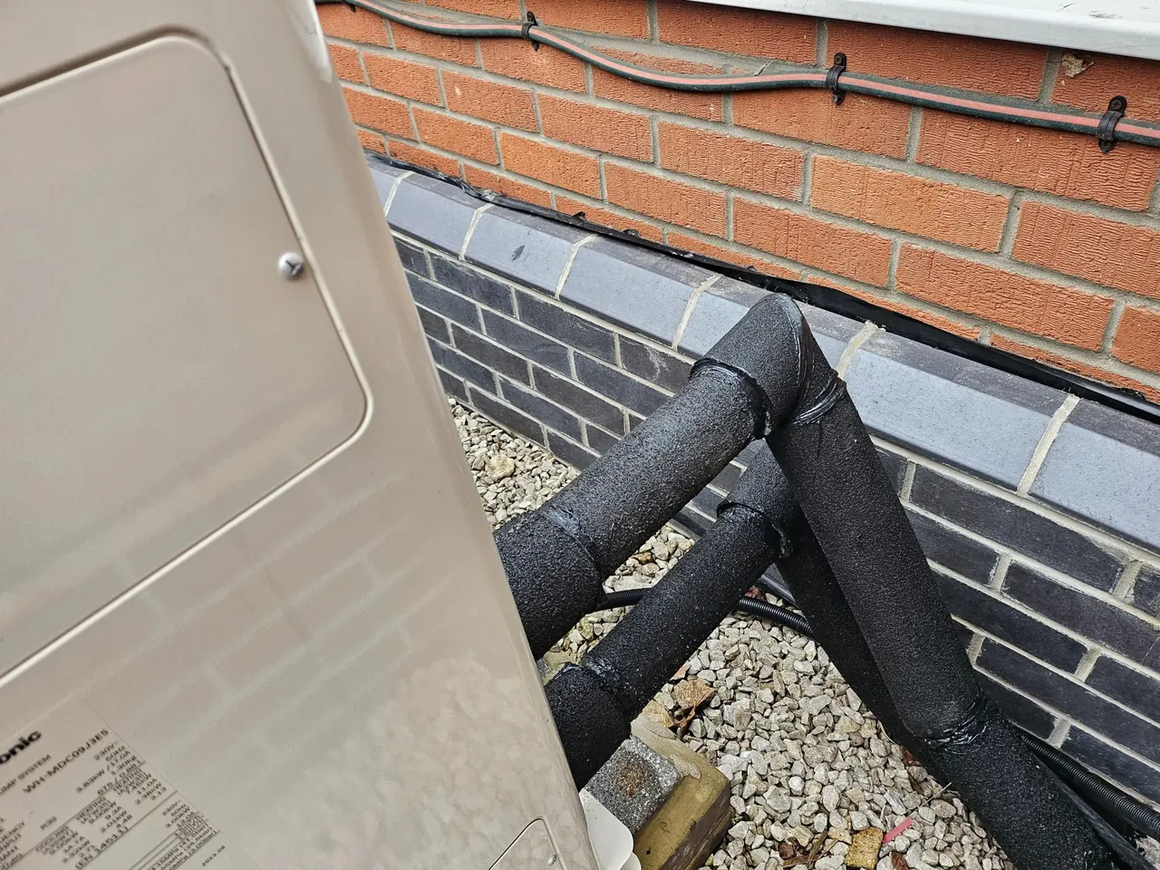 Insulated external pipework showing practical route planning for a heat pump installation.