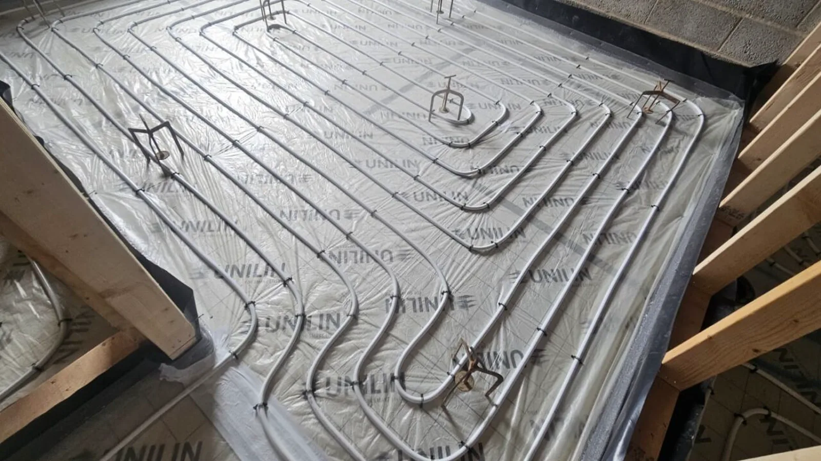 Underfloor heating pipework laid across insulation before screed.